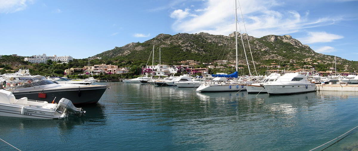 Yachts moored at Porto Cervo marina with scenic hillside backdrop, a top mooring spot in Costa Smeralda