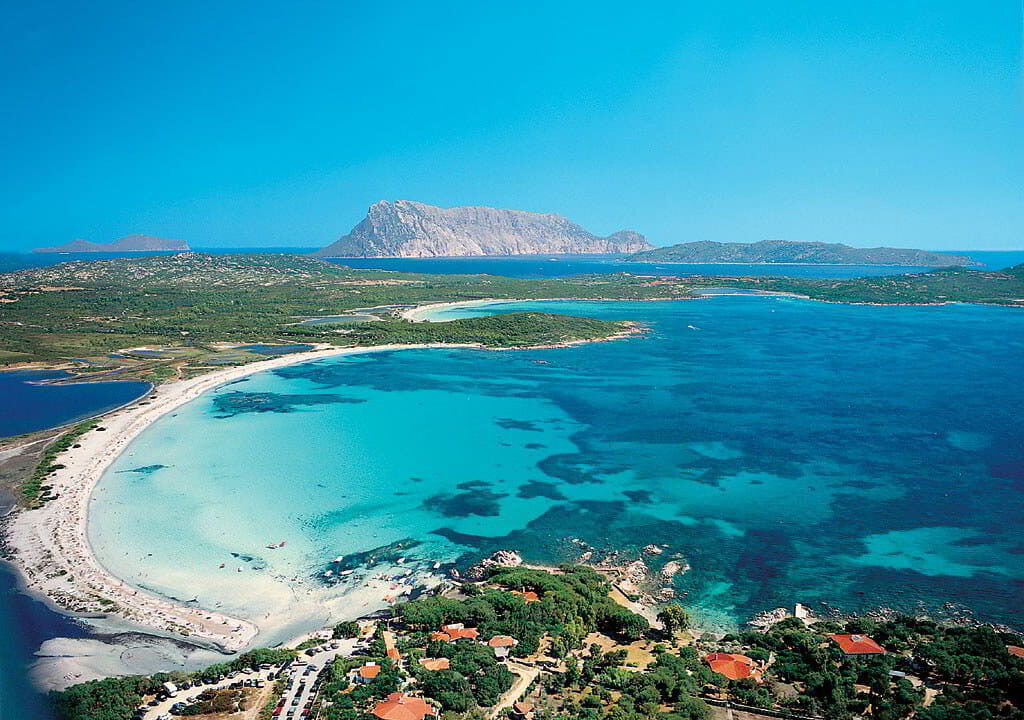 Aerial view of the Puntaldia coastline with turquoise waters and access to the marina near Tavolara island