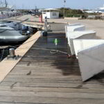 Yacht lounge cushions laid out and being cleaned on deck in sunlight
