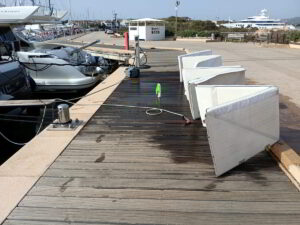 Yacht lounge cushions laid out and being cleaned on deck in sunlight