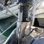 Yacht technician maintaining headsail furler system onboard sailboat in Sardinian marina