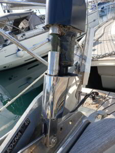 Yacht technician maintaining headsail furler system onboard sailboat in Sardinian marina