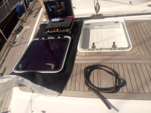 Technician adjusting hatch hinges on deck of sailing yacht